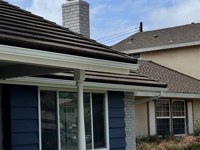 White gutter installed along a Costa Mesa home with a dark roof