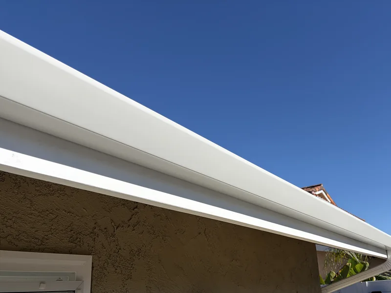 Long white seamless gutter run installed along a residential roofline